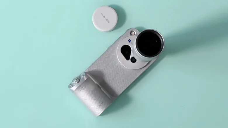 The Vivo X500 Pro Max inside its camera grip case with teleconverter attachment.